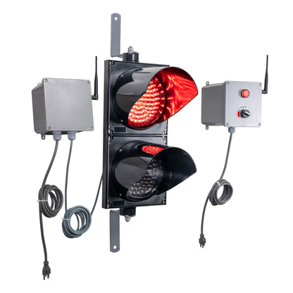 Angled perspective of a wireless traffic light system with red LED light on and accompanying control box transmitter with mirrored pilot light and 2-position switch ton a white background.