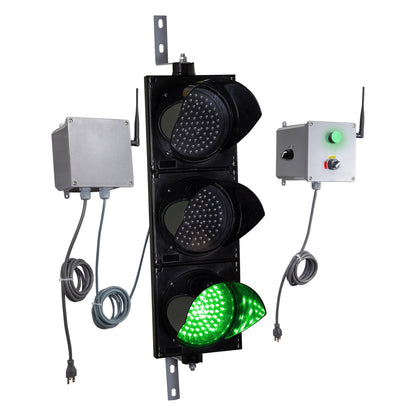 Angled perspective of a wireless traffic light system with green LED light on and accompanying control box transmitter with mirrored pilot light and 3-position switch ton a white background.