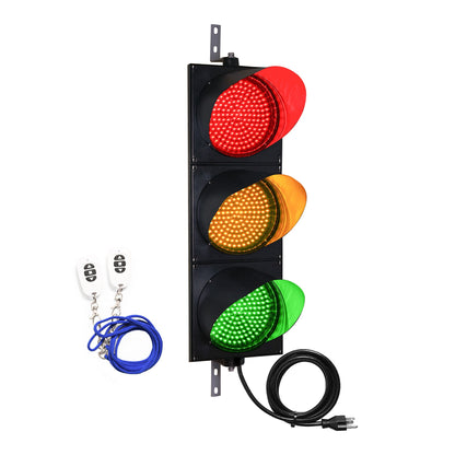 Traffic light with red, yellow, and green lights, two white wireless key fobs and black power cord on a white background.