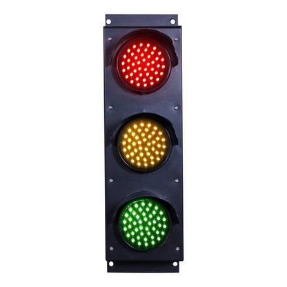 Front perspective of a black three-lens traffic light with red, amber and green light turned on.